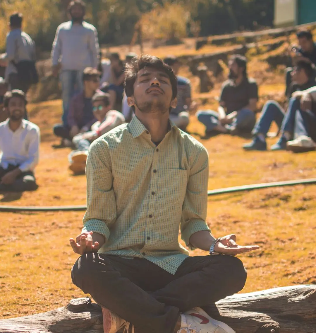 man meditating on tree log